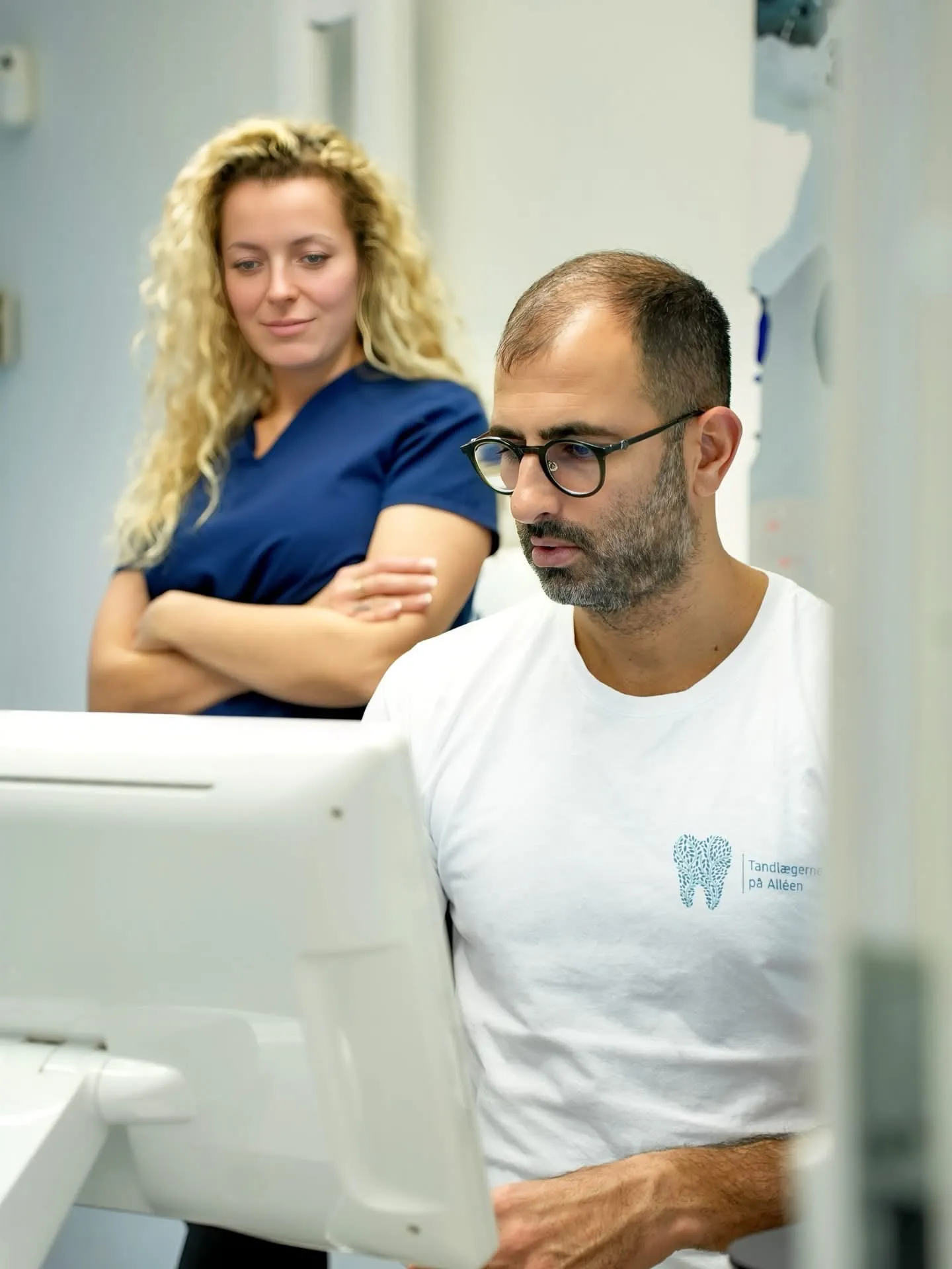 Un dentista y una asistente dental revisan juntos un escaneo digital
